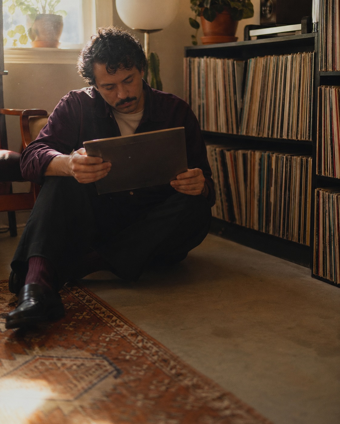 A collector studying a record sleeve at home
